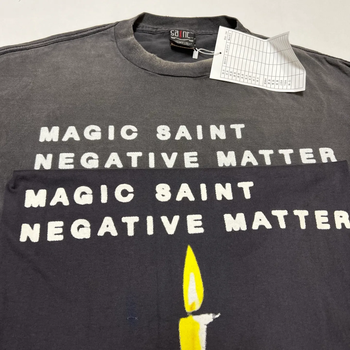 Printing proofing SAINT Mxxxxxx CANDLE LS TEE/BLK Slogan candle distressed long-sleeved TEE Little angel short sleeves on the back Washed black S-XL Original consistent Cylindrical side seam OE yarn fabric Garment dyeing Faded by heavy washes Faded by plaster on bust Correct alignment Original consistent main mark/wash mark/cherub anti-counterfeiting mark Original level printing restoration